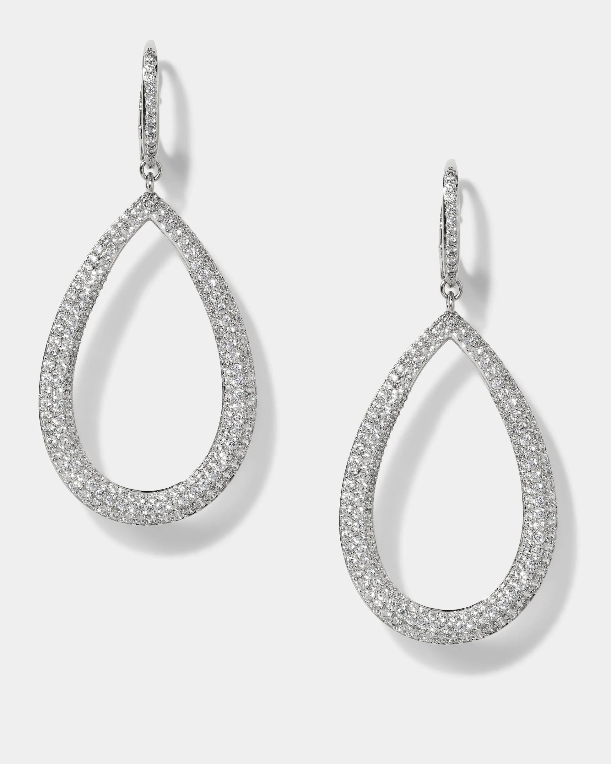 Teardrop-shaped silver earrings with clear gemstones on a light gray background
