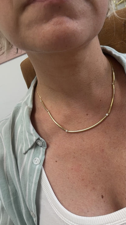 Diamond and gold tube collar necklace shown on the neckline