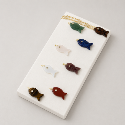 Natural stone fish charm on a gold necklace